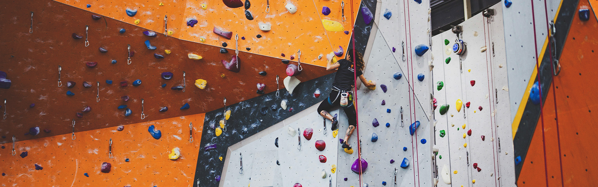Woman climbing a route at an indoor climbing wall. 