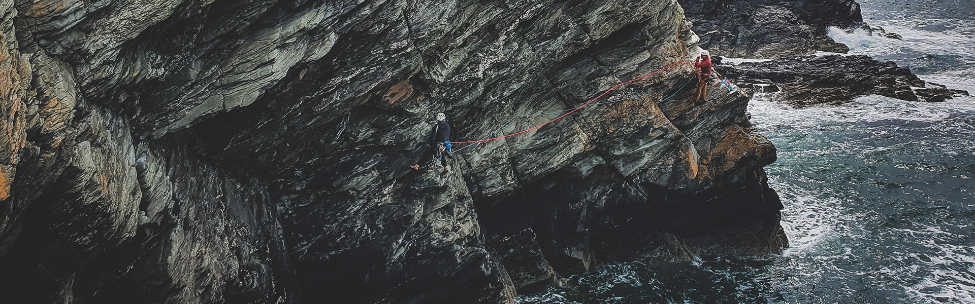 Climbers on the route 'the ramp of pink emulsion' at the range on Holyhead.