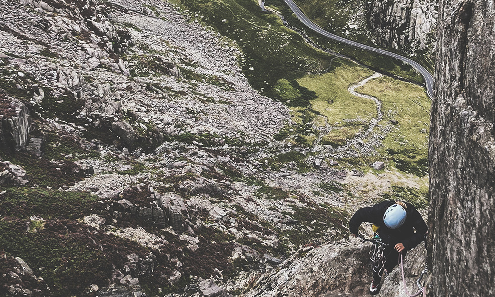 Woman climbing the classic rock routes Flying Buttress in North Wales