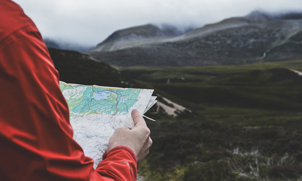 A person reading a map in the Cairngorm National Park in Scotland.