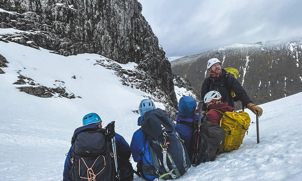 A mountain guide with four clients doing a winter route up Ben Nevis, Scotland.
