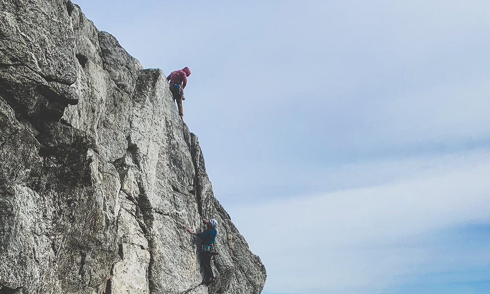 Two climbers at doing a route a Holyhead Mountain in Wales.