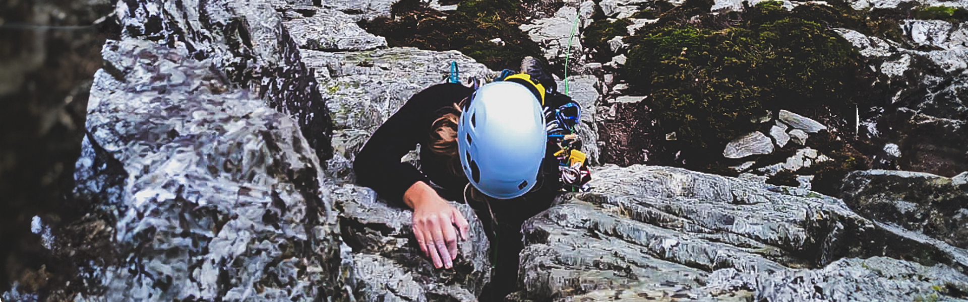 Climber placing gear on a trad route at Holyhead mountain.