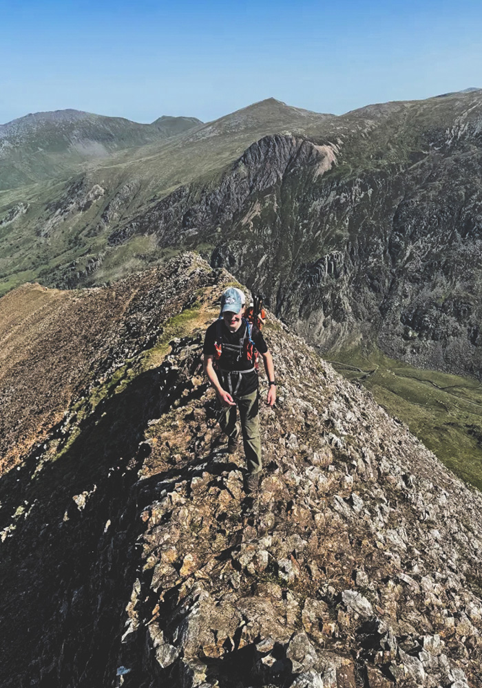 A person walking a long the ridge of Crib Goch in North Wales Snowdonia National Park (eryri)